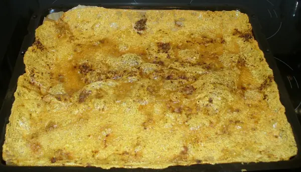 Käsechips liegen frisch und knusprig in einer schwarzen Backform, bereit zum Genießen. Sie sind kalorienarm und gesund.