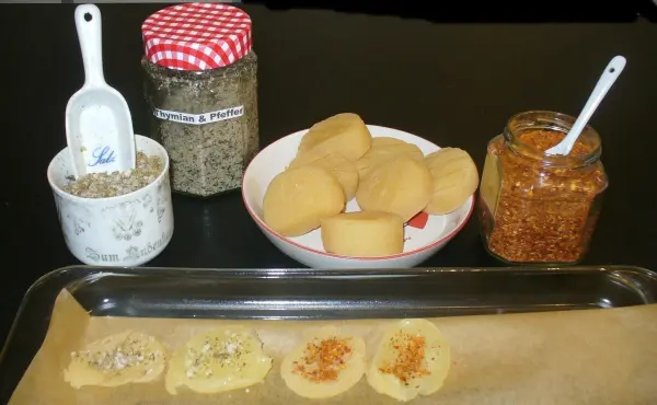 Käsechips auf einem Backblech sind bereit zum Backen, umgeben von Zutaten wie Gewürzen und Marmelade.