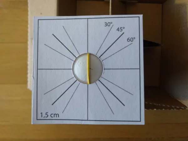 Ein Eierverzierungswerkzeug liegt auf einem Tisch, umgeben von Holz, und zeigt Anleitungen zur Gestaltung von Eiern.