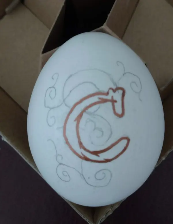 Ein ei wird detailreich mit braunen Linien und geschwungenen Mustern verziert, um es für das Osterfest zu dekorieren.