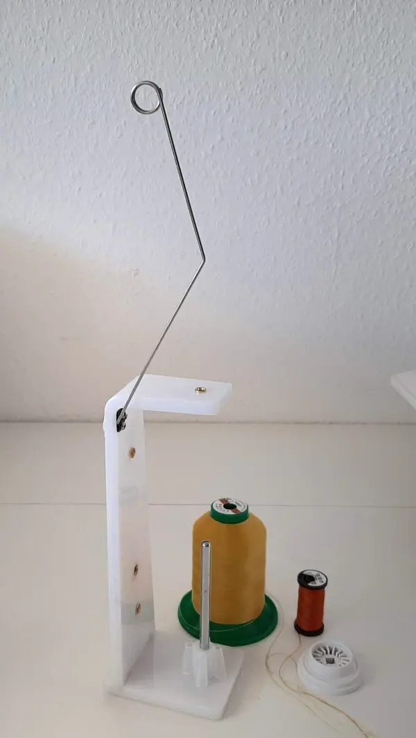 Eine garnspule wird mit einer Drahtaufhängung fixiert, um beim Nähen von Sonnen- und Windschutz effizient zu arbeiten.