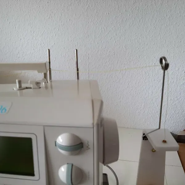 Eine Nähmaschine steht im Raum und hat einen Faden eingefädelt, bereit zum Nähen von Sonnen- und Windschutz.