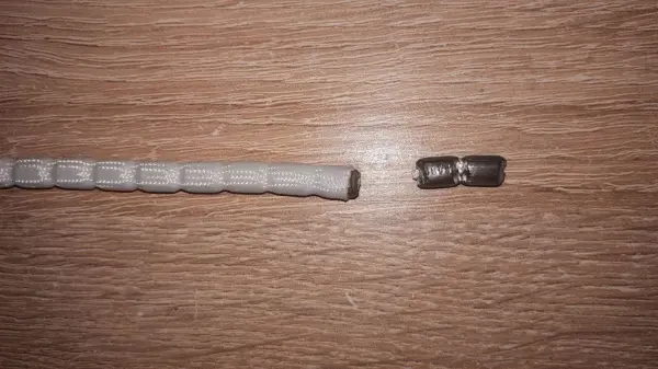 Ein Bleistiftrock links und ein Halter rechts liegen auf einem holzernen Untergrund, der Rock rutscht nicht.