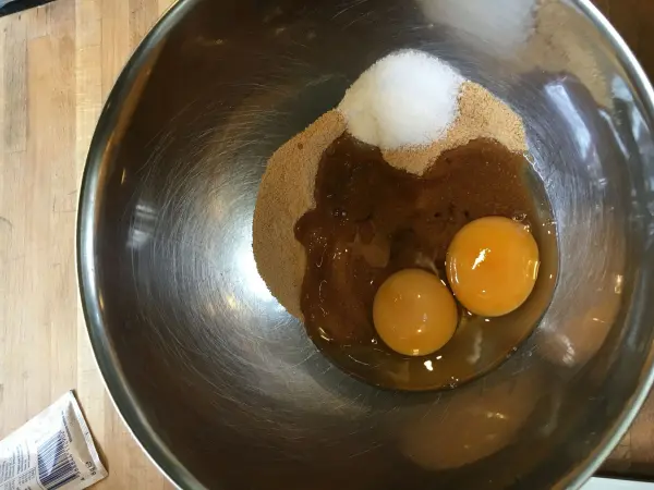 Zwei Eier und Zucker in einer Rührschüssel werden für das Rezept der schwedischen Blaubeer-Tartelettes vorbereitet.
