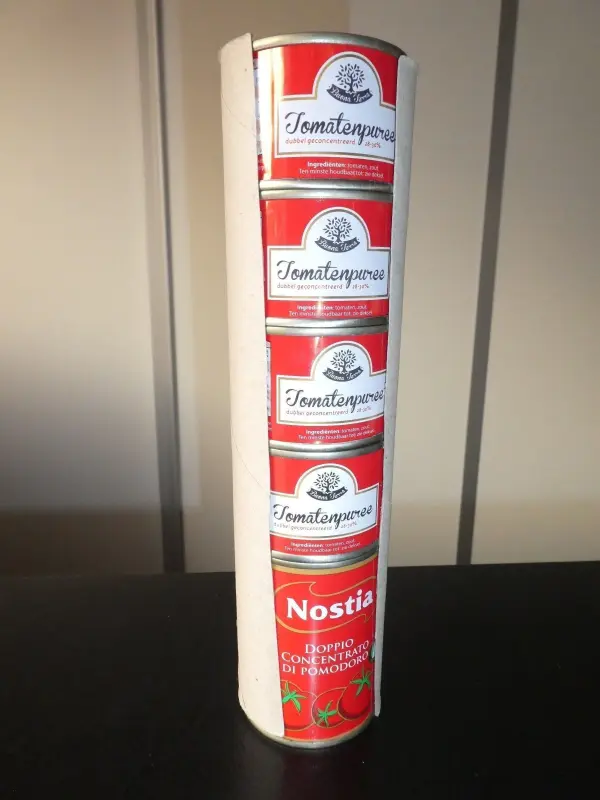 Kleine Dosen sind sicher und ordentlich gestapelt in einer hohen, stabilen Anordnung auf einem Tisch.