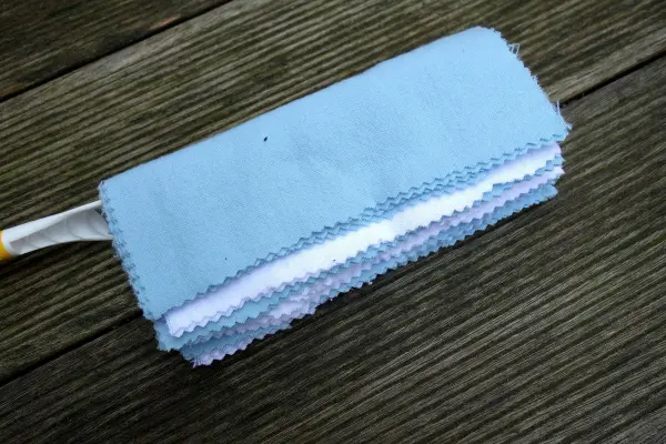 Ein waschbarer Staubwedel liegt auf Holz, bereit zum Staubwischen als umweltfreundliche Swiffer-Alternative.