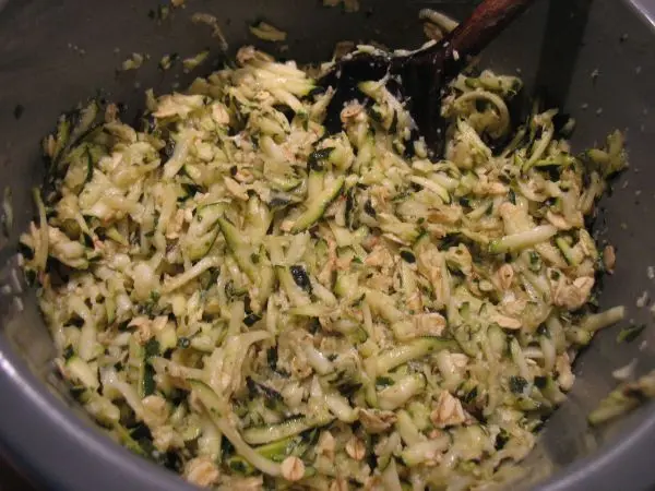 Eine Mischung aus geriebenen Zucchini und Reibekäse liegt in einer Schüssel, bereit zum Formieren von knusprigen Rösti.