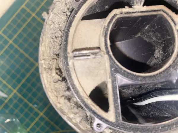 Der gewartete Dyson Staubsauger zeigt angesammelten Staub und Schmutz im Innenbereich, was auf eine mögliche Geruchsquelle hinweist.