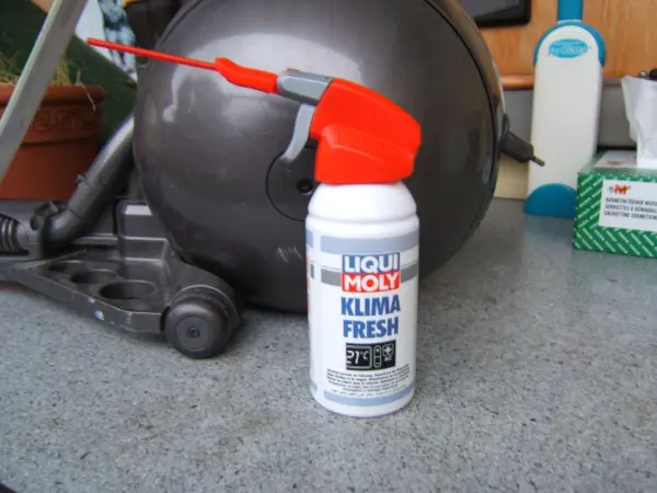 Ein Sprayflasche steht auf einer Arbeitsfläche neben einem Dyson Staubsauger, um Gerüche zu beseitigen.
