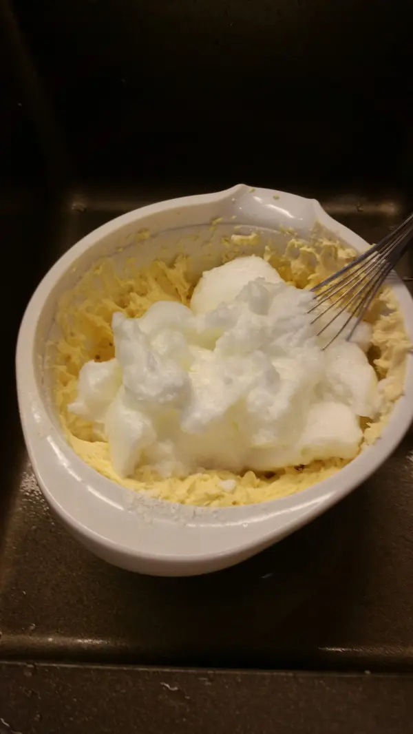 Eine Schüssel mit einer Mischung aus Quark und steif geschlagenem Eiweiß, bereit zum Backen eines Quark-Gugelhupfs.