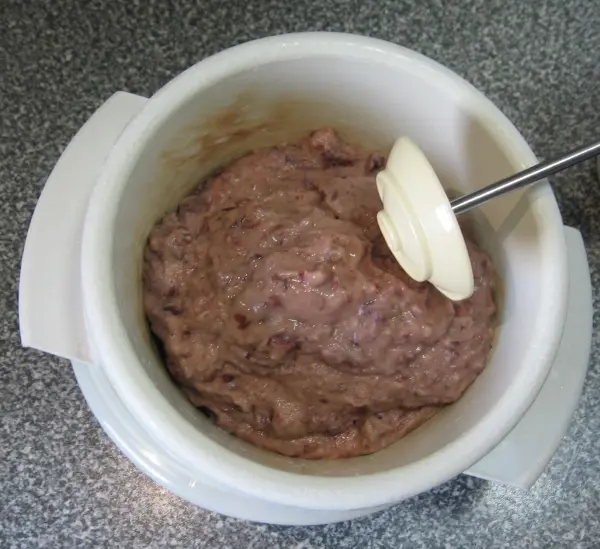 Eine Mischung aus Linsen und Fleisch wird in einer Schüssel mit einem Rührgerät zubereitet, um Frikadellen zu formen.
