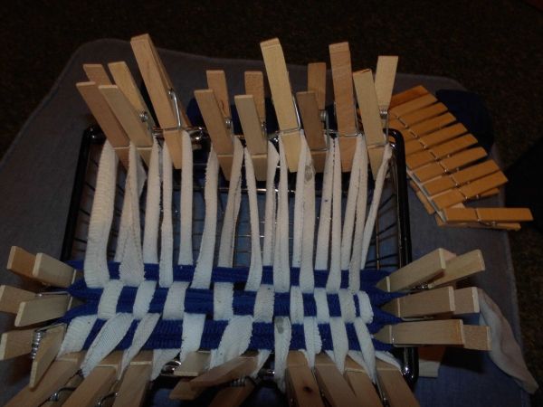 Ein geflochtener Putzlappen aus alten T-Shirts wird auf einem Gestell mit Holzklammern fixiert, um die Form zu halten.