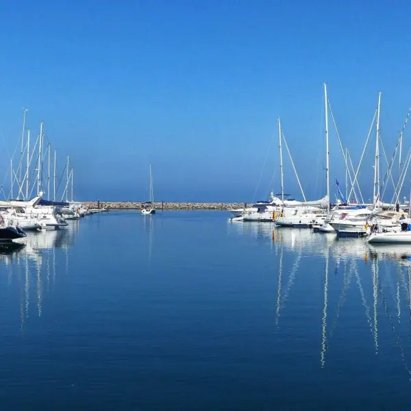 Schöne Yachten liegen ruhig im wasserstillen Hafen, unter einem klaren blauen Himmel, perfekt für beeindruckende Reiseziele.