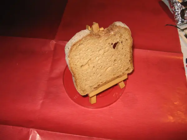 Ein Toastscheibe steht auf einem kleinen Ständer und wird auf rotem Untergrund präsentiert, um knusprig zu bleiben.
