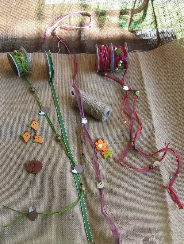 Bunte Bänder und Dekorationsmaterialien werden kreativ angeordnet, um herbstlich zu dekorieren, auf einem hellen Untergrund.
