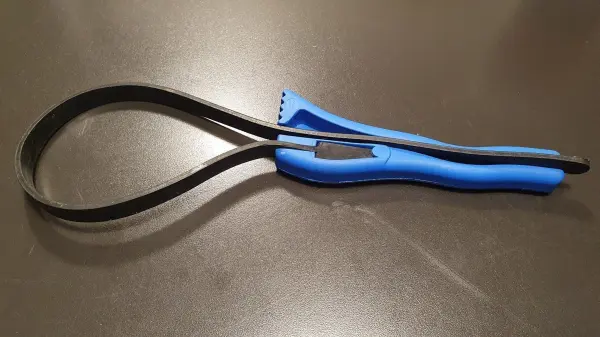 Ein blauer Schraubverschlussheber liegt auf einer dunklen Oberfläche und ist bereit, den Deckel von einem Glas zu öffnen.