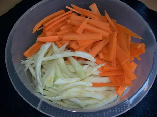 Gestreifte Möhren und Fenchel liegen frisch in einer Schüssel, bereit zur Zubereitung eines Lachsgerichts.