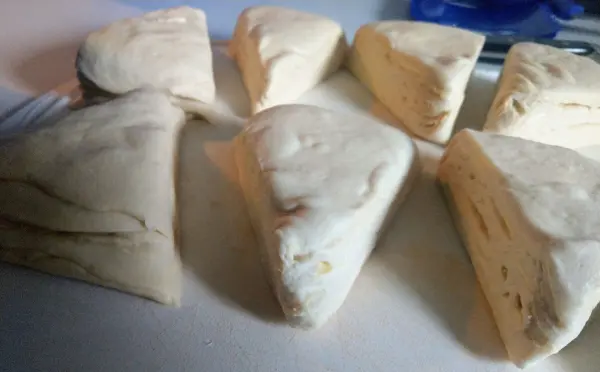 Drei eckige Laugendreiecke liegen auf einem Tisch, bereit zum Backen in einer gemütlichen Küche.