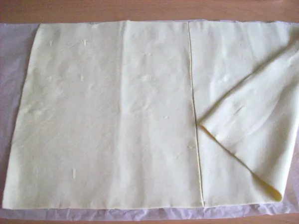 Ein Blatt Blätterteig liegt auf einer Arbeitsfläche, bereit zur Weiterverarbeitung für die Zubereitung von Pasteis de Belem.