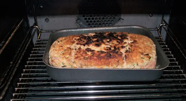 Ein Falscher Hase, goldbraun gebacken mit Kräutern und Champignons, steht im Ofen und lässt einen köstlichen Duft verbreiten.