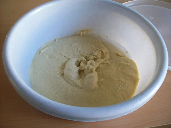 Eine Schüssel mit weichem, cremigem Marzipan liegt auf einem Tisch, bereit für die Zubereitung von Christstollen.