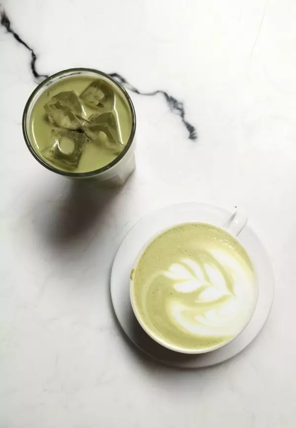 Matcha Latte kann sowohl heiß als auch kalt getrunken werden. Der Matcha wird zusammen mit geschäumter Milch und etwas Agavendicksaft in einem hohen Glas serviert.