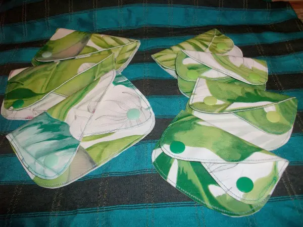 Bunte Geldtaschen aus Stoff liegen auf einem gestreiften Untergrund, bereit zum Verwenden oder Verschenken.