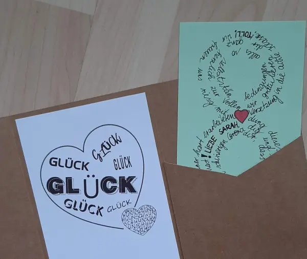 Eine bunte Glückwunschkarte liegt in einem Umschlag und gratuliert liebevoll zur Versetzung in die nächste Klasse.