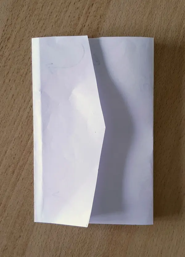 Eine leere Glückwunschkarte liegt offen auf einem Holztablett, bereit, eine Botschaft zur Versetzung zu empfangen.