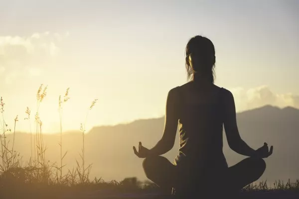 Eine entspannte Runde Yoga oder Meditation lindert Stress und wirkt damit auch fettigen Haaren entgegen.