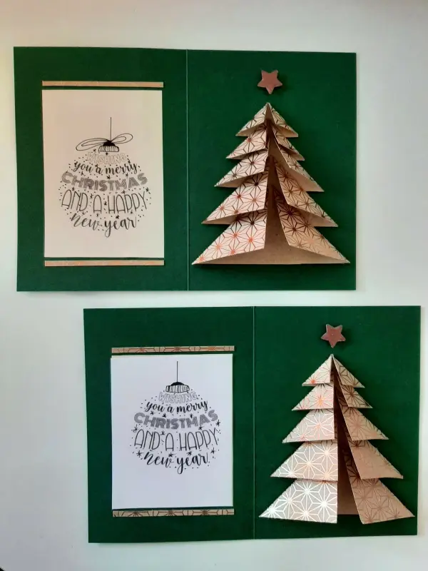 Eine gefaltete Weihnachtskarte zeigt einen dekorativen Tannenbaum aus Papier auf grünem Hintergrund mit festlichen Sprüchen.