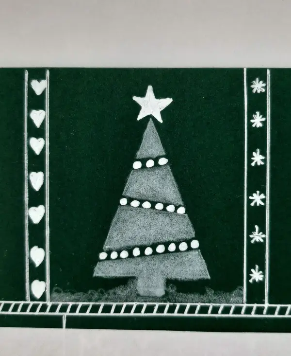 Eine gefaltete Weihnachtskarte zeigt einen dekorativen Tannenbaum mit Stern und Herzen auf grünem Hintergrund.