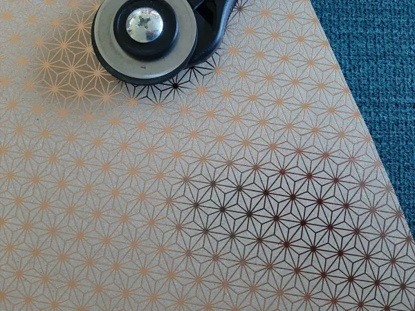 Ein graues Blatt mit goldenem, sternförmigem Muster wird mit einem Cutter bearbeitet, um eine Weihnachtskarte zu gestalten.
