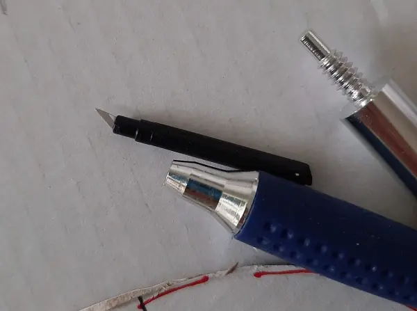 Ein schwarzer Stift liegt neben einem silbernen Kugelschreiber auf einer hellen Fläche, bereit zum Schreiben oder Zeichnen.