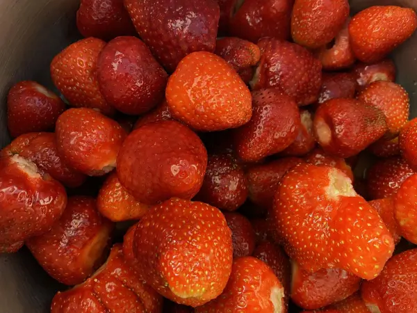 Saftige Erdbeeren liegen in einem Topf und warten darauf, in einen erfrischenden Erdbeer-Limes für die Grillparty verarbeitet zu werden.