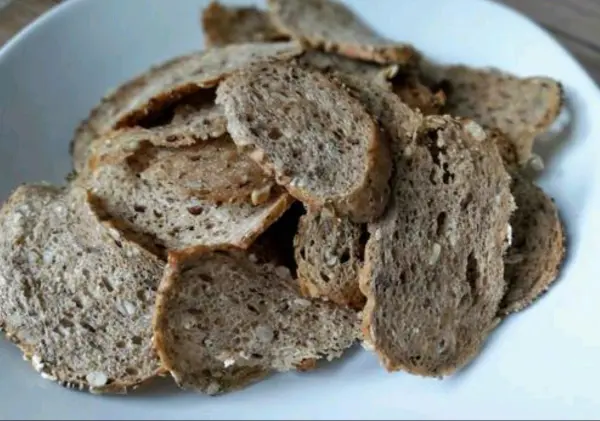 Knusprige Brotscheiben liegen übereinander in einer weißen Schüssel, bereit zum Genießen als Snack oder Beilage.