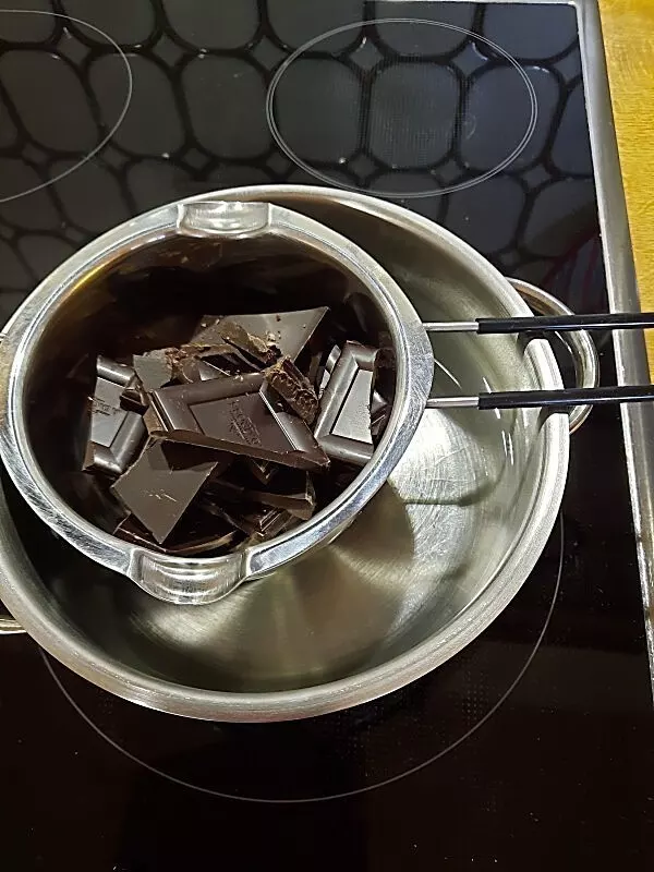 Für diese Schokotorte braucht man u. a. geschmolzene, dunkle Schokolade. Über heißem Wasser schmilzt sie dahin.
