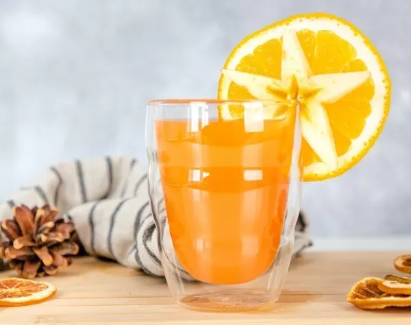 Als Weihnachtscocktail wird der heiße Aperol mit einer Orangenscheibe und einem Apfelstern dekoriert. 