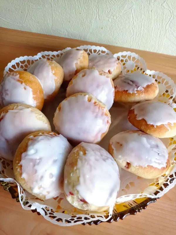 Leckere Berliner mit Zuckerglasur liegen in einer dekorativen Schale auf einem Holztisch.