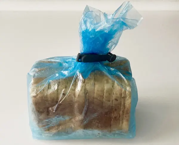 Ein Laib Brot in einer blauen Plastiktüte, sicher verpackt, um Frische zu bewahren, bereit zum Einfrieren und Toasten.