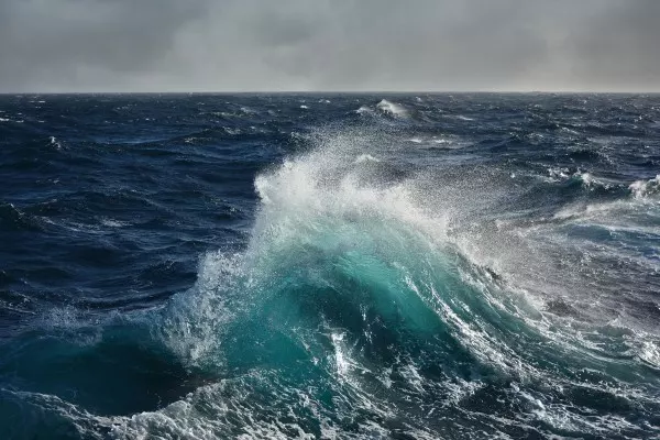 Der Wind pustet über das Meer und schubst winzig kleine Wasserteilchen an. Dadurch entsteht dann eine Welle.