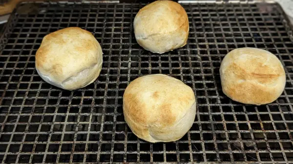 Vier goldbraune Berliner auf einem Grillrost, frisch aus der Heißluftfritteuse, warten darauf, serviert zu werden.