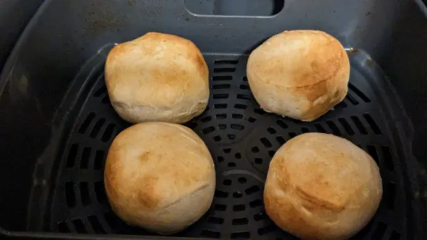 Vier knusprige Berliner ruhen in einer Heißluftfritteuse, bereit zum Genießen. Ideal für eine leichte Snack-Zeit.