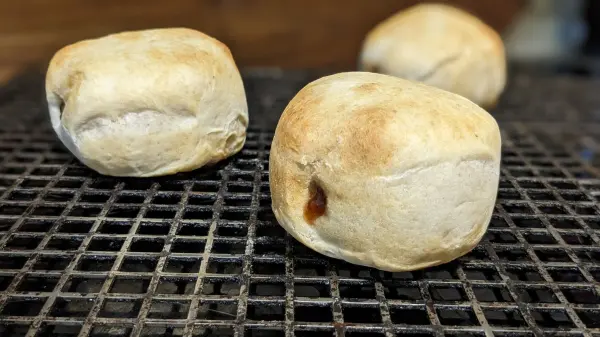 Drei frittierte Berliner liegen auf einem Gitterrost, frisch zubereitet in der Heißluftfritteuse, appetitlich gebräunt.