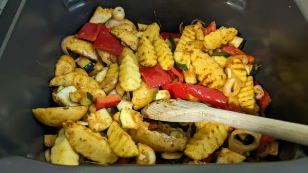 Bunte Gemüsepfanne mit gewürztem Schweinefilet, zubereitet in der Heißluftfritteuse, wirkt appetitlich und frisch.