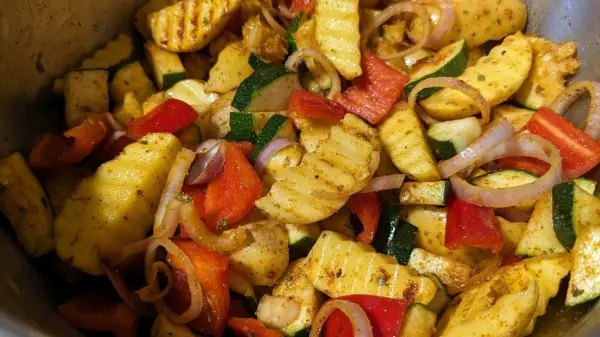 Bunte Gemüsepfanne mit Zucchini, Paprika und Zwiebeln, die in einer Heißluftfritteuse zubereitet wird.