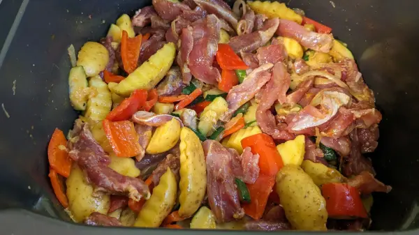 Bunte Gemüsepfanne mit mariniertem Schweinefilet und Kartoffeln, alles zusammen in einer Heißluftfritteuse zubereitet.