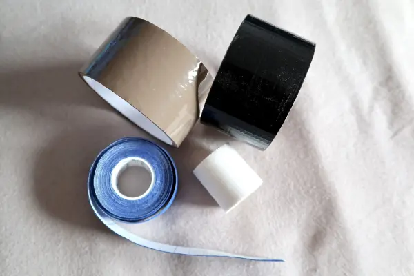 Klebeband liegt auf einem hellen Hintergrund, verschiedene Farben und Breiten deuten auf Anwendung gegen Warzen hin.