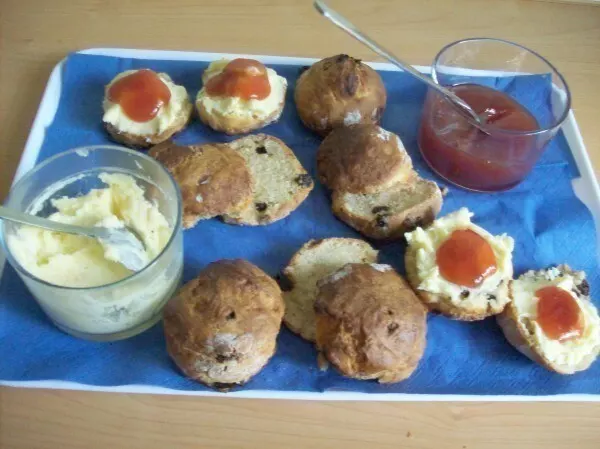 Durchgeschnitten werden die kleinen irischen Scones Gebäcke mit Clotted Creme und Erdbeermarmelade bestrichen und zum Tee gegessen.