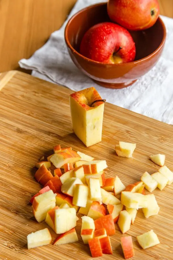 Für das Bratapfel-Kompott schneidest du drei Äpfel in kleine Würfel.